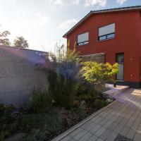 Gartenhaus in Sichtbeton Optik vor rotem Haus
