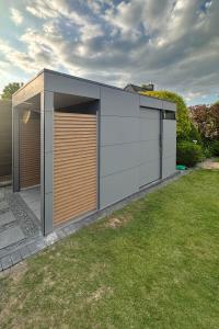 Graues Gartenhaus mit Vordach