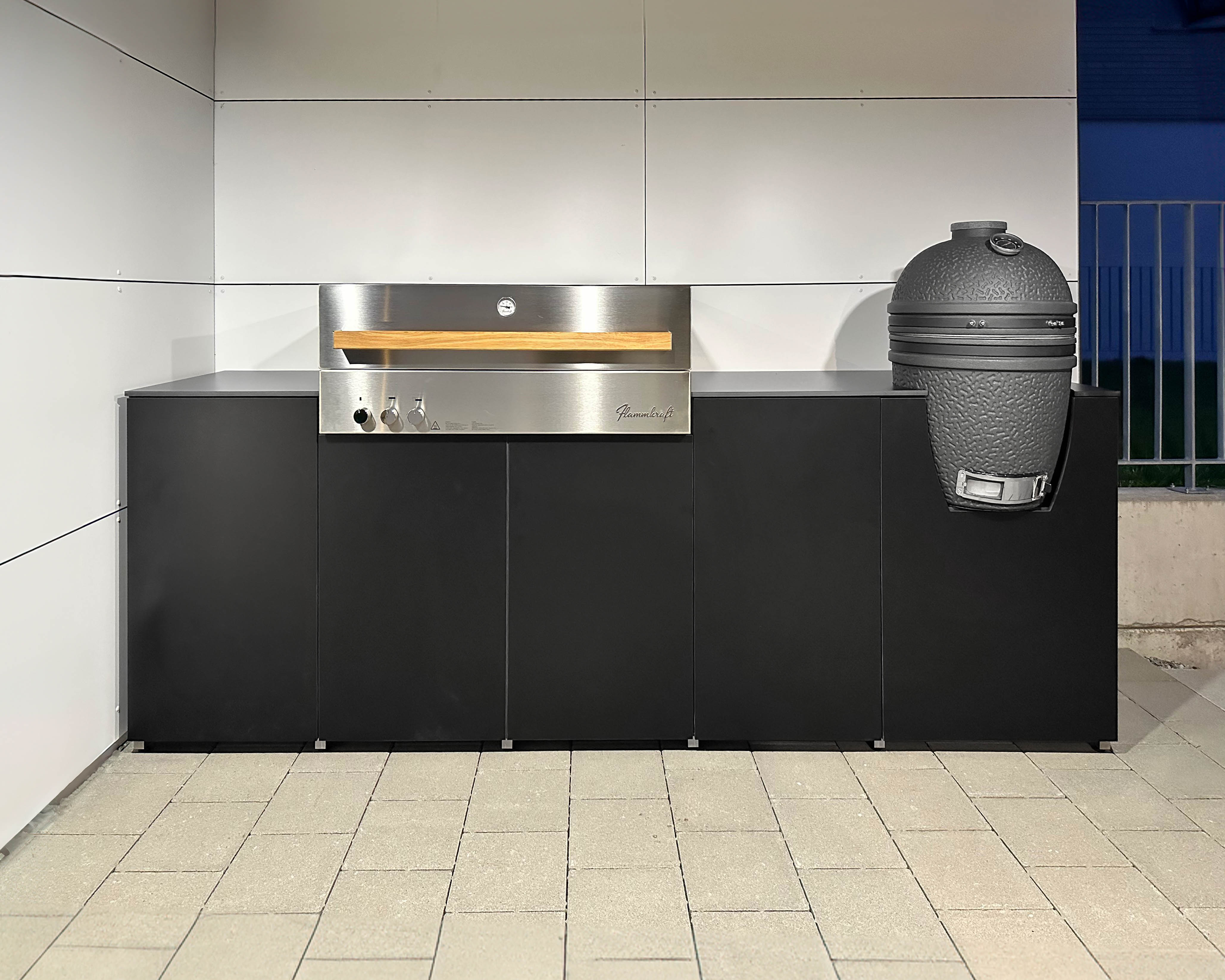 Black outdoor kitchen with Flammkraft built-in barbecue and Big Green Egg 2
