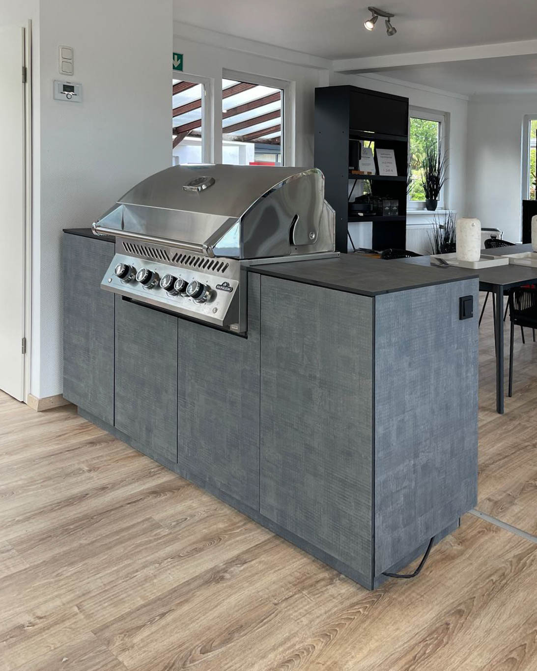 Small, grey outdoor kitchen with built-in Napoleon barbecue 1