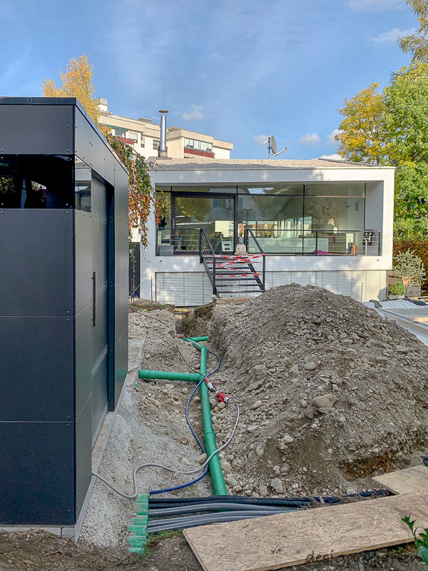 Moderna caseta de piscina con techo plano como núcleo técnico en Landsberg am Lech