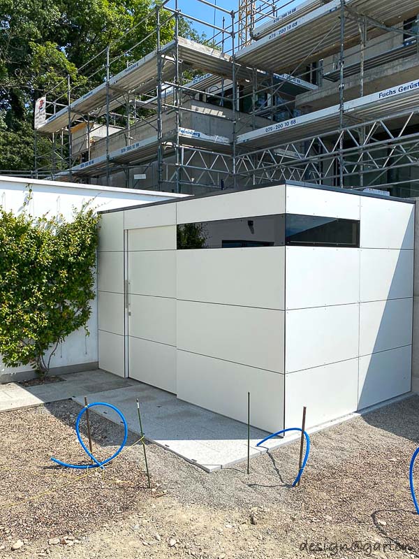 Caseta de jardín cubista con techo plano como solución doble en el lago de Zúrich