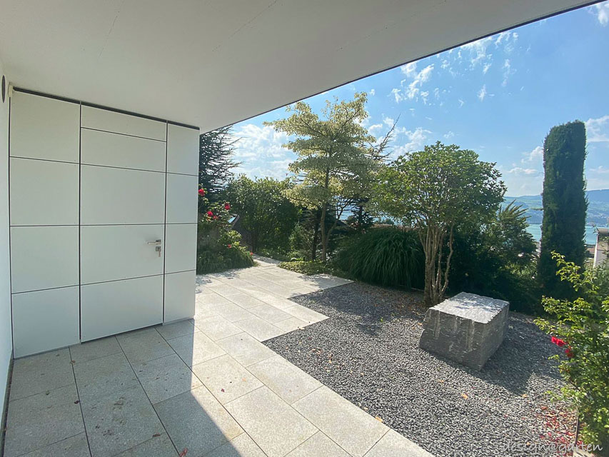 Caseta de jardín cubista con techo plano como solución doble en el lago de Zúrich