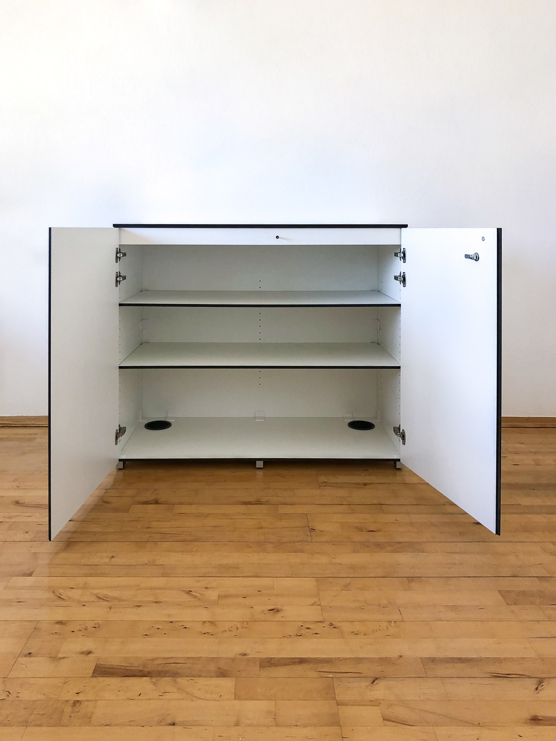 Moderner weißer Schrank aus HPL geöffnet mit Fachböden