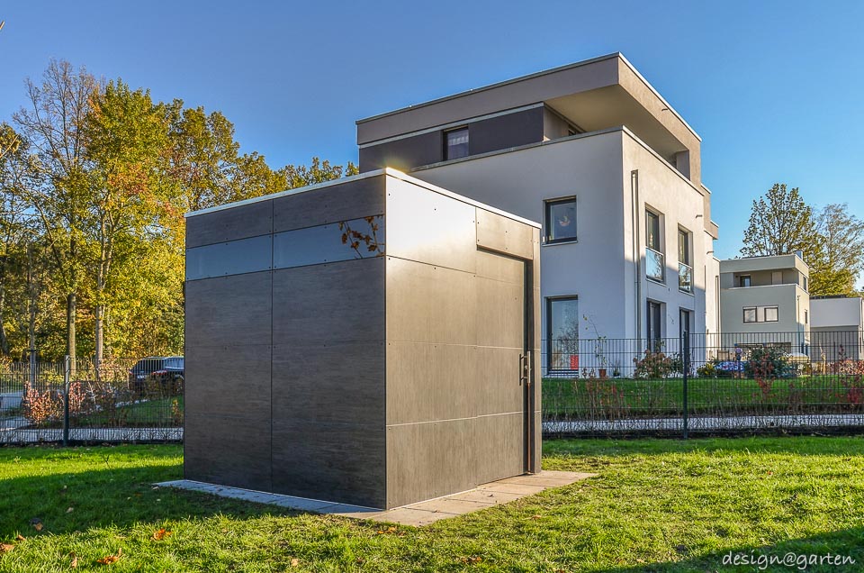 Symbiose architecturale : cabane de jardin cubiste en HPL faisant écho à la façade