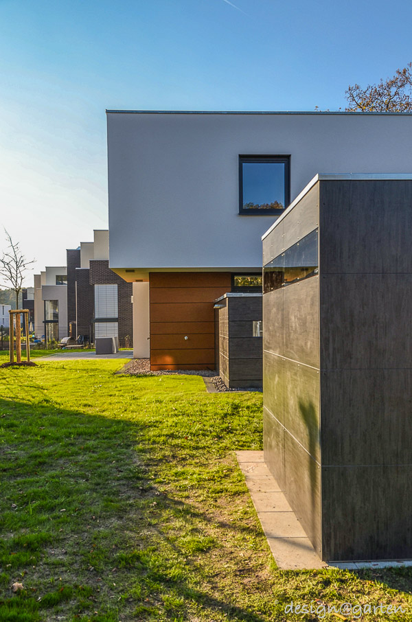 Symbiose architecturale : cabane de jardin cubiste en HPL faisant écho à la façade