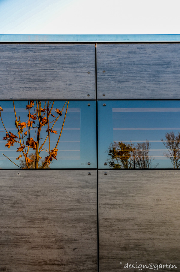 Symbiose architecturale : cabane de jardin cubiste en HPL faisant écho à la façade
