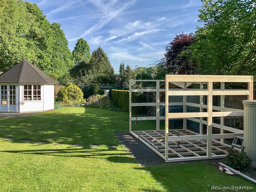 Contrastes dans le jardin : une cabane de jardin à toit plat en HPL rencontre le charme d'une maison de campagne