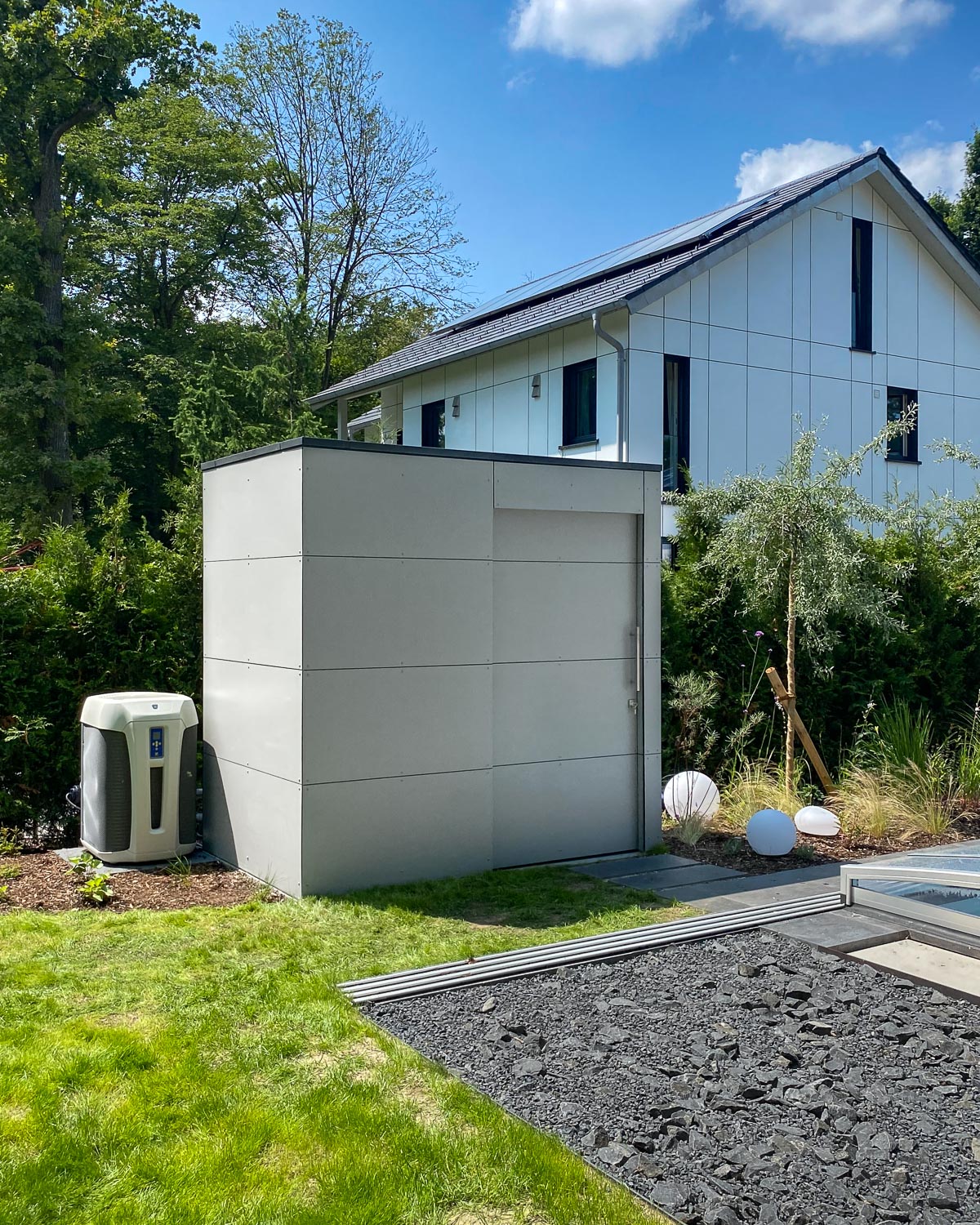 Pool house moderne avec porte coulissante servant espace de rangement et abritant les équipements techniques de la piscine 1