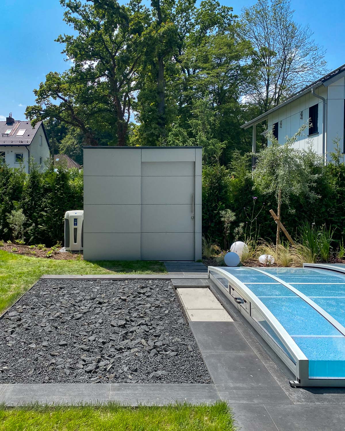 Pool house moderne avec porte coulissante servant espace de rangement et abritant les équipements techniques de la piscine 2