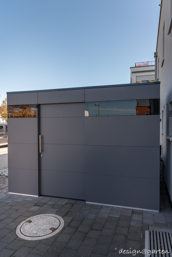 Casetta lineare nel giardino anteriore come moderno garage per biciclette